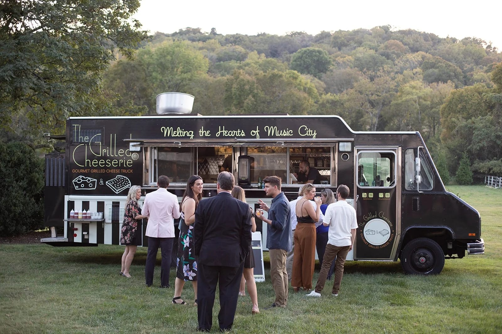 The Grilled Cheeserie food truck serving guests at a golden-hour event